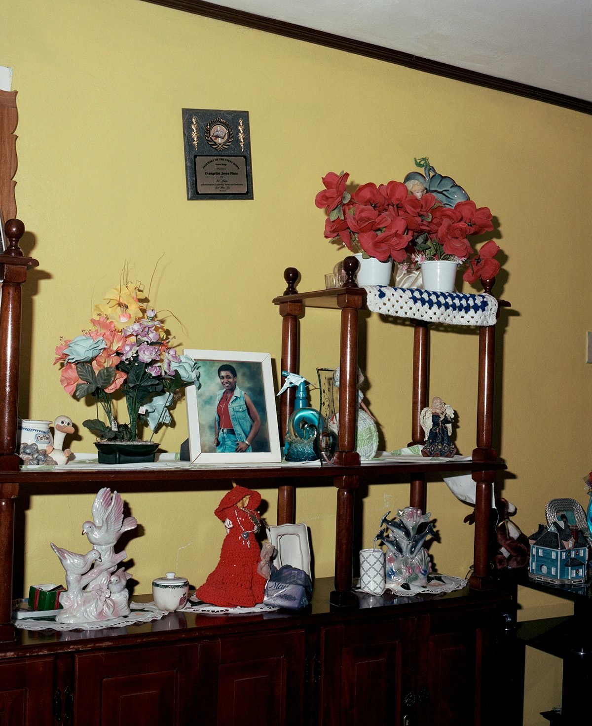 Photo by Kwabena Sekyi Appiah-nti of a large wooden display table covered in ornaments, flowers and photos