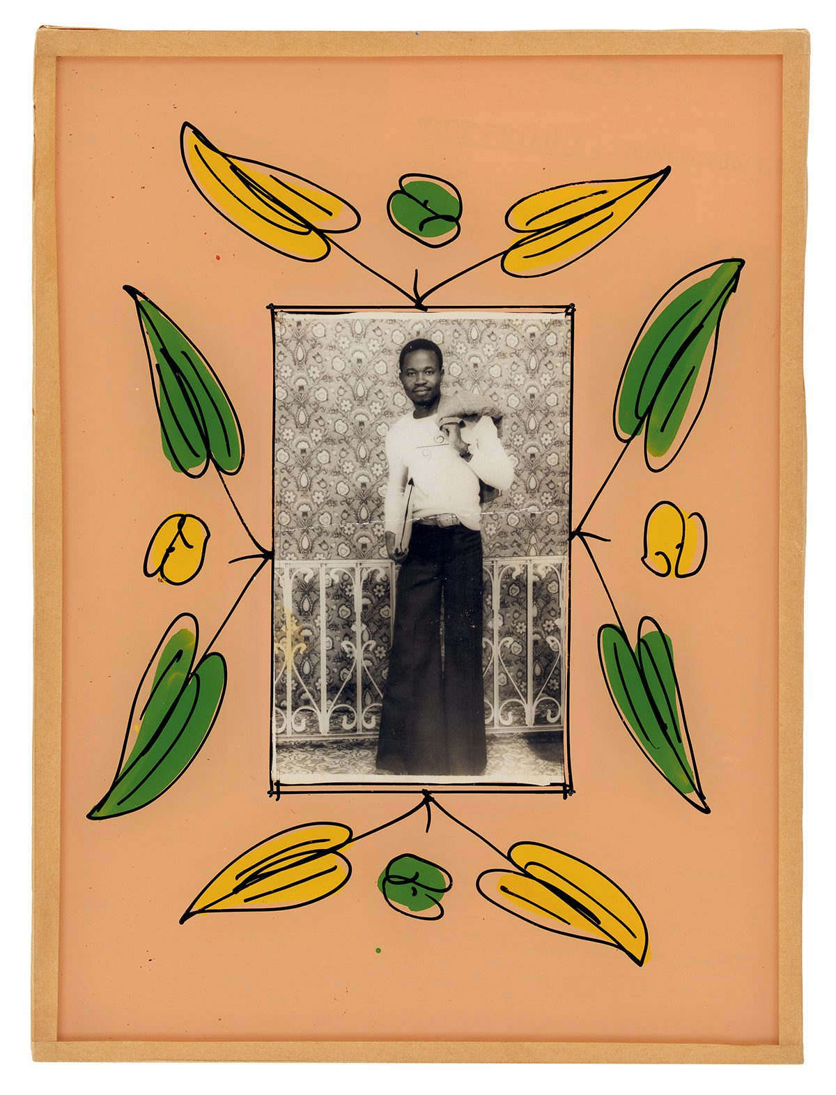 Black and white photo of a person posing in a studio, which is bordered by a peach coloured painted frame with green and yellow leaves