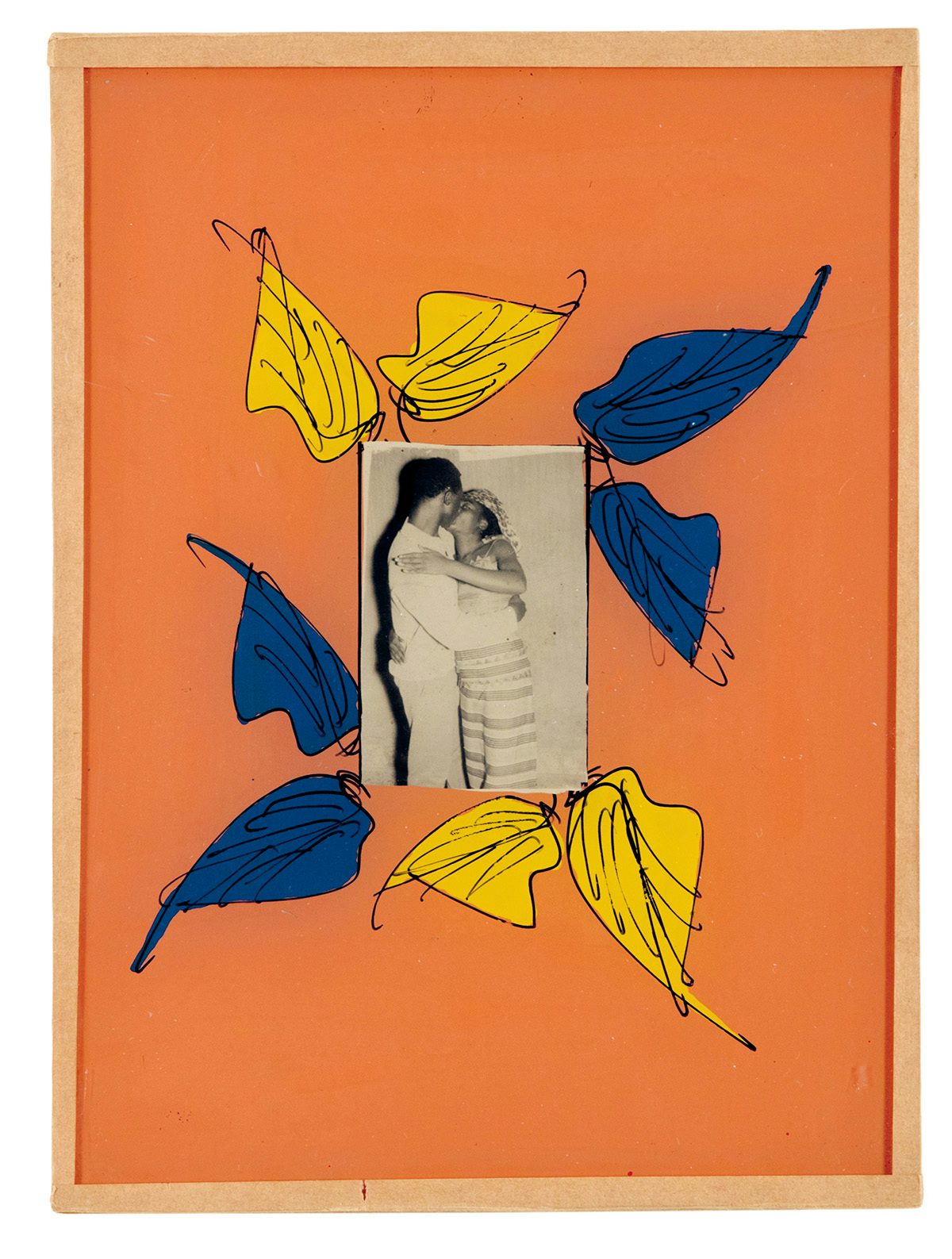 Black and white photo of two people embracing, which is bordered by an orange painted frame with blue and yellow leaves
