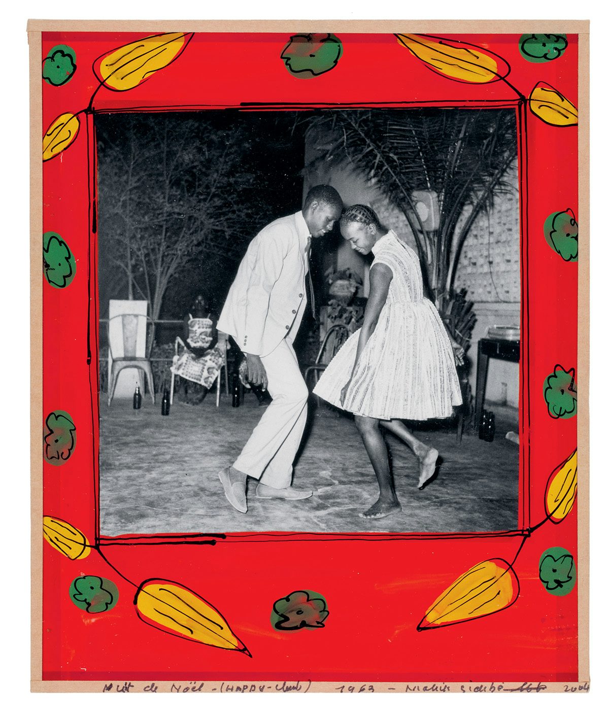 Black and white photo of two people in a suit and dress and dancing barefoot outside, which is bordered by a red painted frame