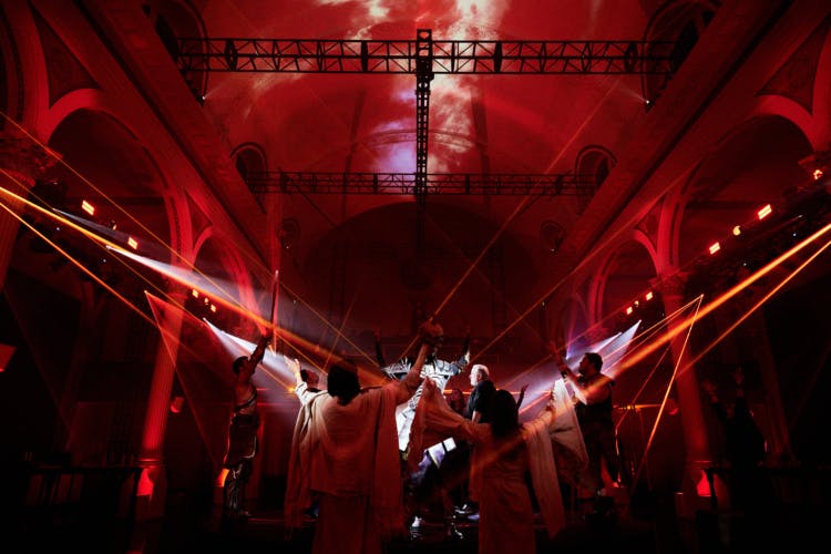A crowd in a red hued hall at the Diablo IV event by Studio Secret Cinema