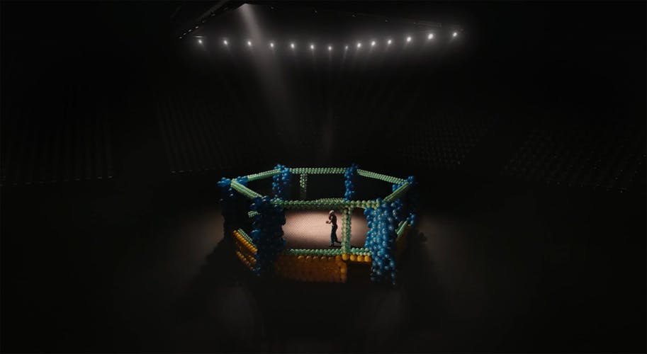 Still from a SickKids Foundation advert showing a young person in a boxing ring in the centre of a darkened room