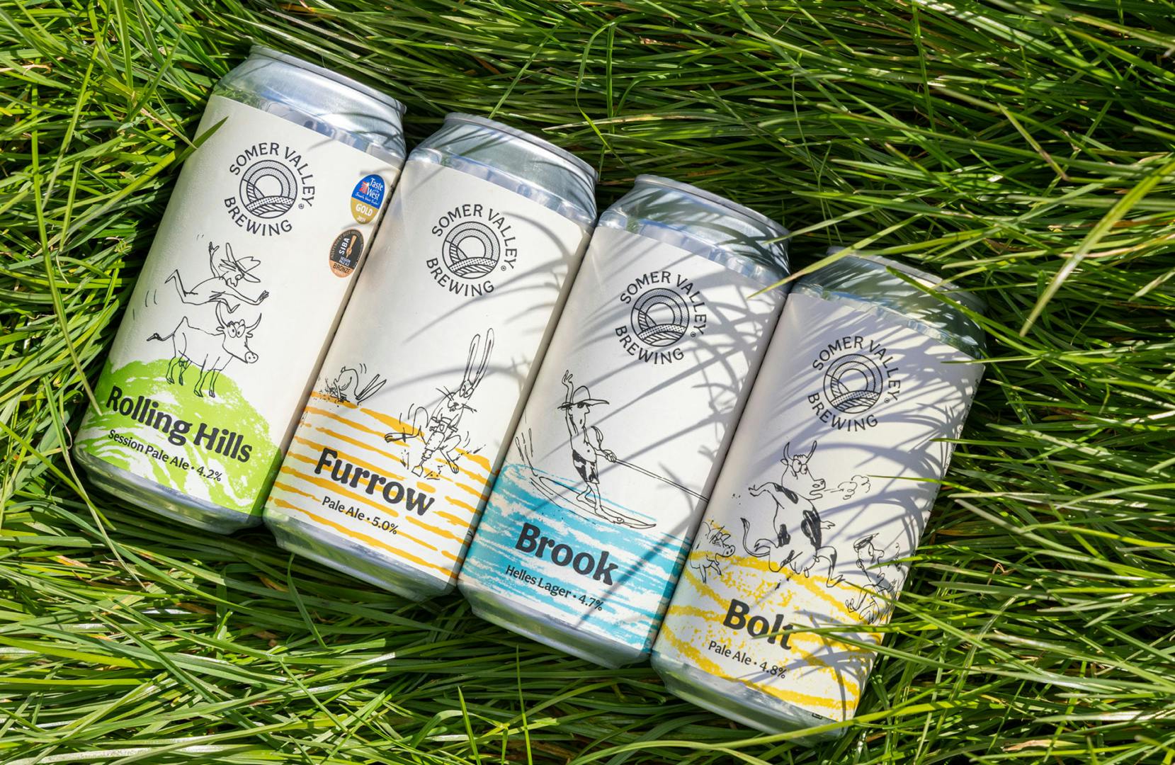 Four Somer Valley Brewing drinks cans resting on grass, each with a colourful label and rough illustration of eccentric farmers and cattle
