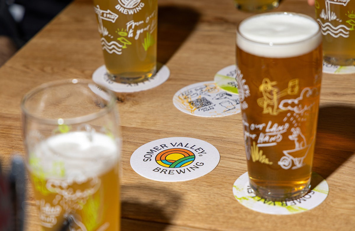 Table covered with pints in Somer Valley Brewing glasses and beer mats